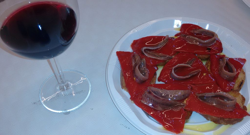 Tosta de pimiento rojo y anchoa con aceite y Copa de vino tinto