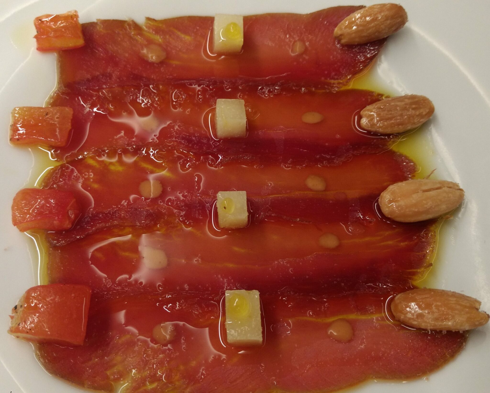 Mojama con salpicón de tomates, queso fresco y almendras